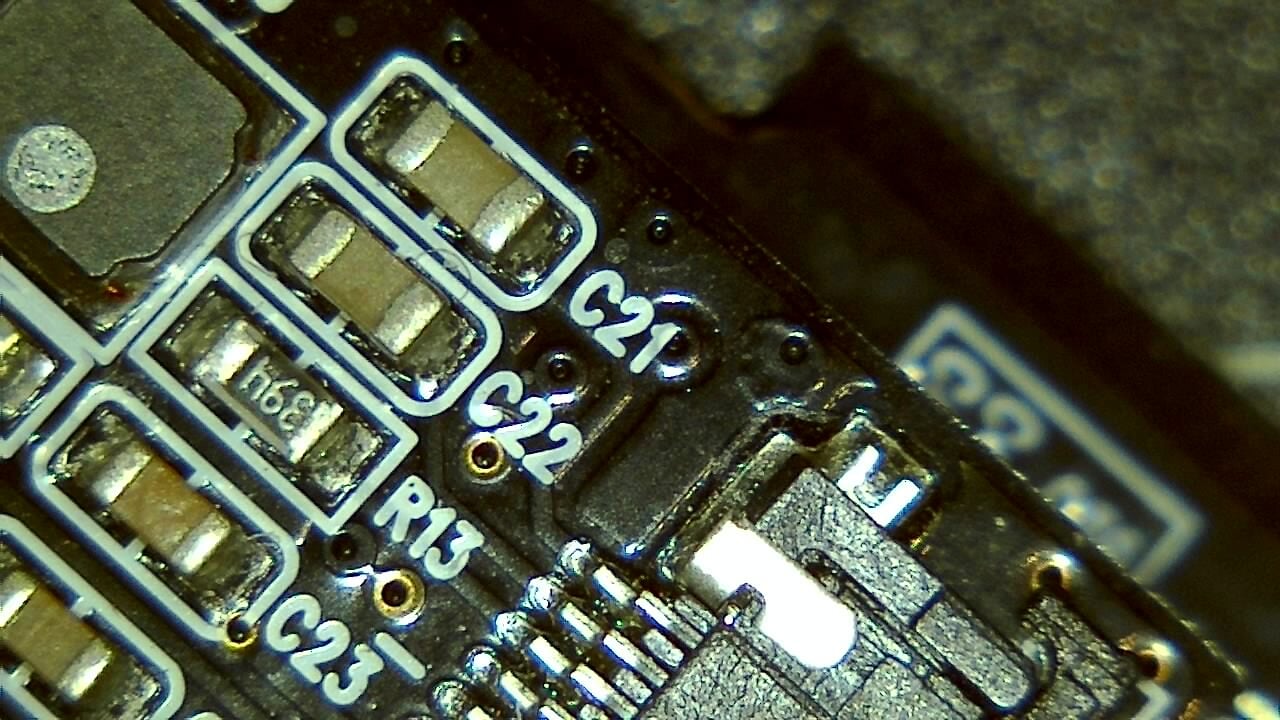 Sample PCB microscope image showing soldered components and labeled pads